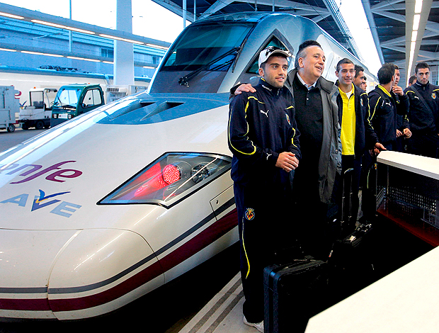 jogadores do Villareal posam ao lado de trem