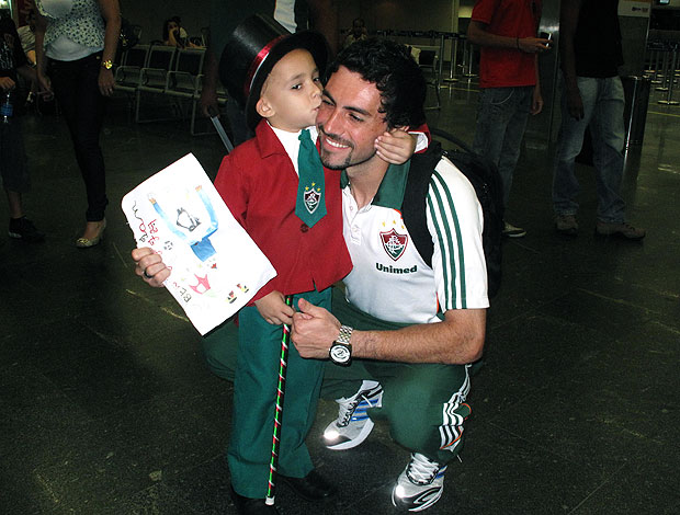 Ricardo Berna com criança no embarque do Fluminense (Foto: Cahê Mota / GLOBOESPORTE.COM)