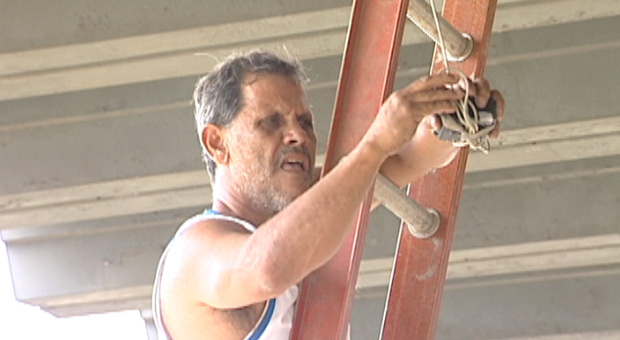 Róbson Santana, presidente da Desportiva Ferroviária, consertando o placar eletrônico do estádio Engenheiro Araripe (Foto: Reprodução/TV Gazeta)