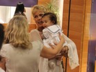 Xuxa segura bebê de fã durante passeio em shopping no Rio