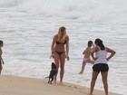 Fiorella Matheis brinca em praia carioca com cachorro
