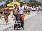 Rafael Calomeni não descuida do corpo nem do filho em dia de praia