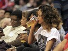 Rihanna assiste a jogo de basquete com copo de cerveja na mão
