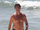 Felipe Camargo exibe barriguinha em caminhada em praia no Rio