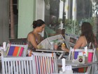 Mônica Carvalho lê jornal enquanto almoça