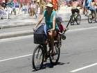 Grávida, Cynthia Howlett carrega a filha na garupa em passeio de bike