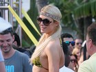 Com look riponga, Paris Hilton baba pelo namorado em festa na piscina