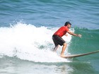 De bigodão, Humberto Martins surfa na praia da Macumba, no Rio