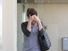 Sem maquiagem, Mila Kunis esconde o rosto ao deixar academia