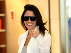 Sorridente, Fernanda Vasconcellos acena para fotógrafo em aeroporto