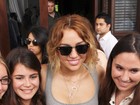 De vestido curto e justo, Miley Cyrus posa com fãs em Miami