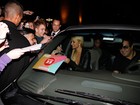 Paris Hilton atende fãs ao deixar hotel