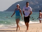 Luma de Oliveira caminha na praia com personal
