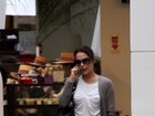 Carolina Ferraz não desgruda do celular ao passear em shopping