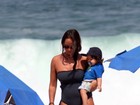 Mulher de Ricardo Pereira leva o filho à praia, no Rio