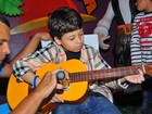Filho de Nívea Stelmann e Mario Frias toca violão em festa de aniversário