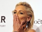 Sharon Stone usa decote revelador e maquiagem laranja em jantar na Itália