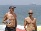 Marcos Caruso caminha sem camisa em orla de praia carioca
