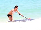 Com prancha personalizada, José Loreto faz stand up paddle na praia