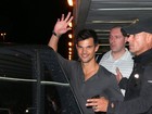 Taylor Lautner acena para fotos ao desembarcar no Rio