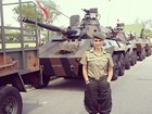 Flávia Alessandra posa caracterizada ao lado de tanques do exército