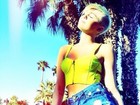 Miley Cyrus posa de shortinho jeans sob o sol