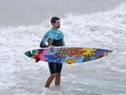 Com prancha multicolorida, Cauã Reymond surfa em praia do Rio