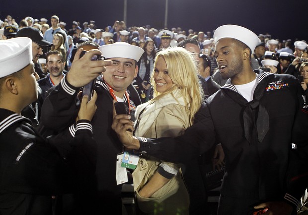 Pamela Anderson é cercada por marinheiros durante jogo de basquete em porta-aviões, na Califórnia (Foto: Reuters)