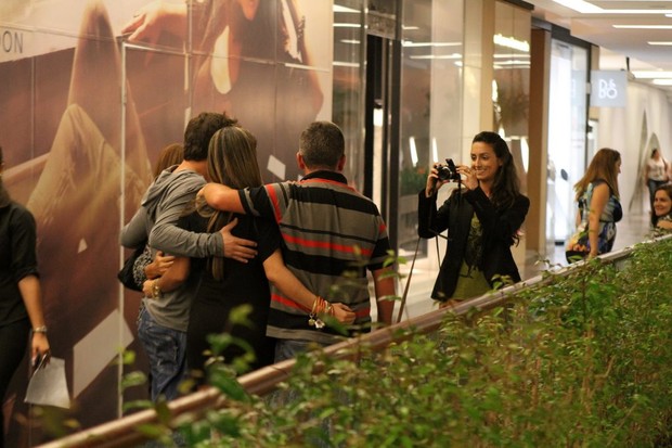 Marcelo Faria posa para fotos com fãs enquanto é fotografado pela mulher Camila Lucciola em shopping no Rio (Foto: Daniel Delmiro/ Ag. News)