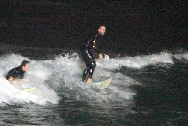 Gabriel "O Pensador" surfa de noite na praia do Arpoador no RJ (Foto: André Freitas/ Ag. News)