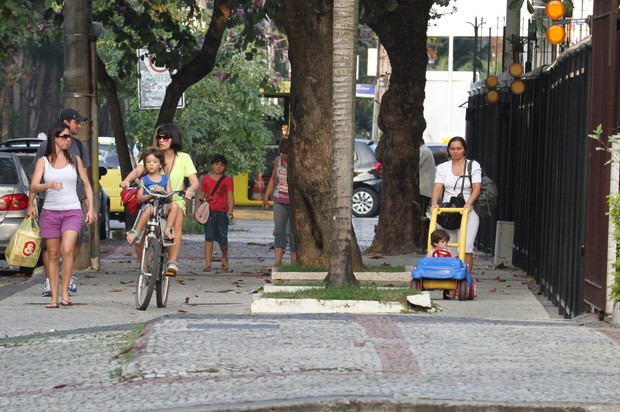 Vanessa Giácomo vai com os filhos para casa, um na garupa da bike, o outro na carrinho. (Foto: Ag News/ Dilson Silva)