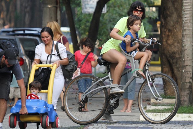 Vanessa Giácomo vai com os filhos para casa, um na garupa da bike, o outro na carrinho. (Foto: Ag News/ Dilson Silva)
