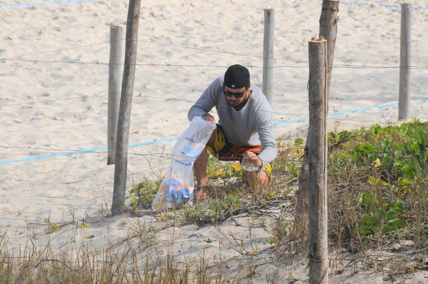 Paulo Vilhena catando lixo na praia do Recreio, no Rio (Foto: Francisco Silva / AgNews)