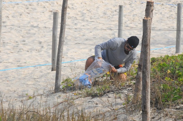 Paulo Vilhena catando lixo na praia do Recreio, no Rio (Foto: Francisco Silva / AgNews)