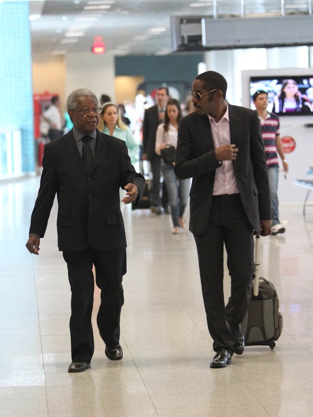 Lázaro Ramos e Milton Gonçalves no aeroporto posando com fãs (Foto: Alice Silva  / AgNews)