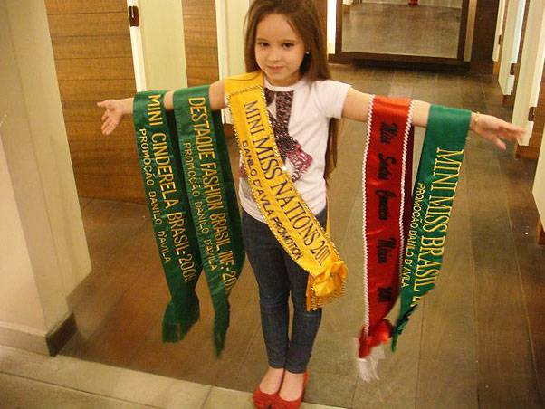 Ana Clara, de 7 anos, exibe as cinco faixas dos títulos que conquistou desde 2007 (Foto: Arquivo pessoal)