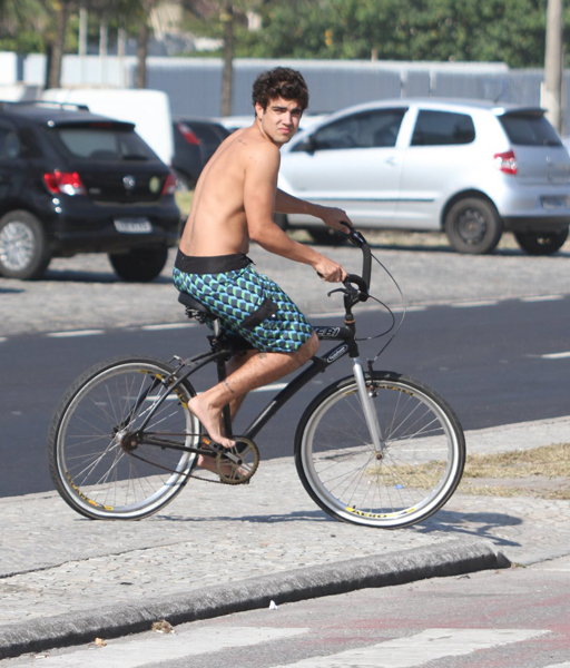 Caio Castro pedalou descalço e sem camisa pela orla da praia da Barra da Tijuca, na Zona Oeste do Rio