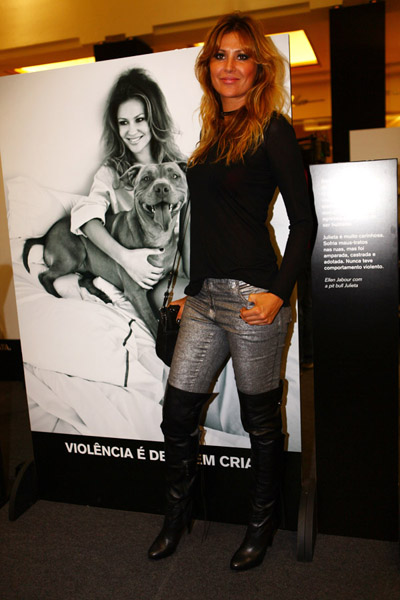 Ellen Jabour posa ao lado do retrato que fez para a ONG Ampara Animal