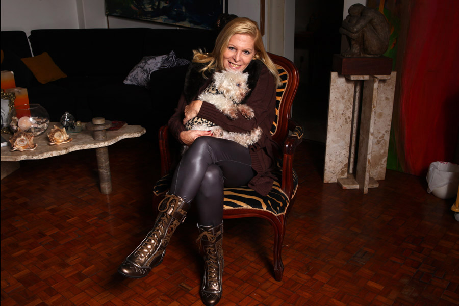 Vanusa com seu cachorrinho, Totó, na sala do apartamento em que vive na região central de São Paulo