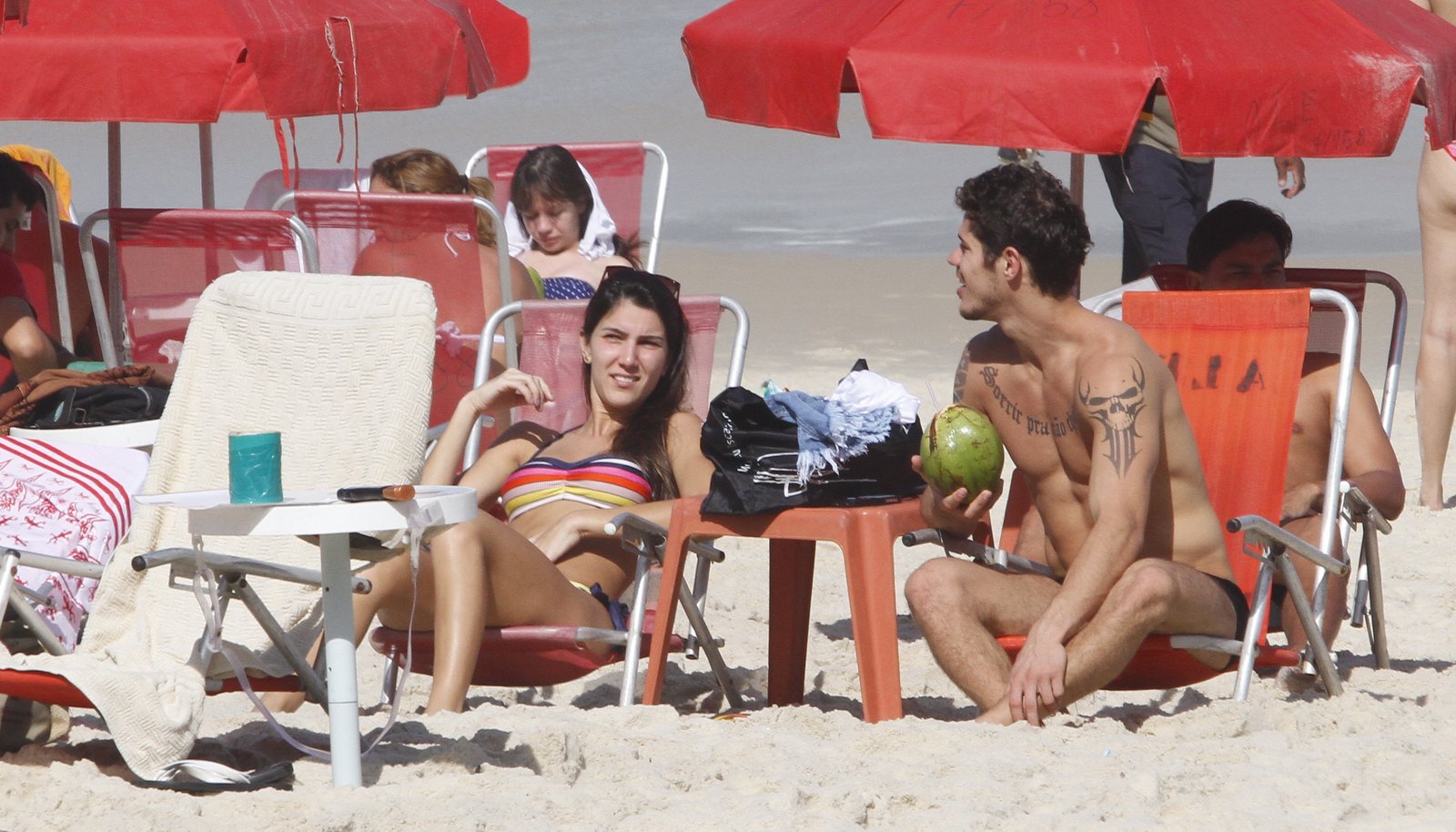José Loreto pegou sol e tomou água de coco com a namorada na praia da Barra da Tijuca
