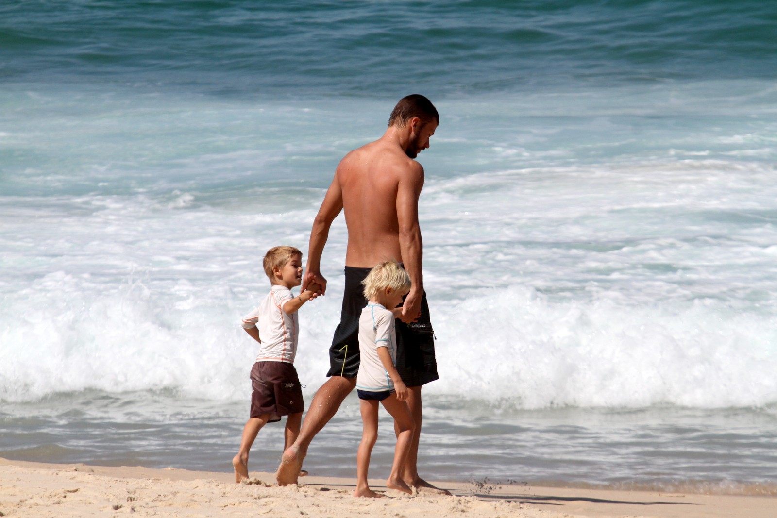 Rodrigo Hilbert leva João e Francisco para a beira da água na praia do Leblon, no Rio