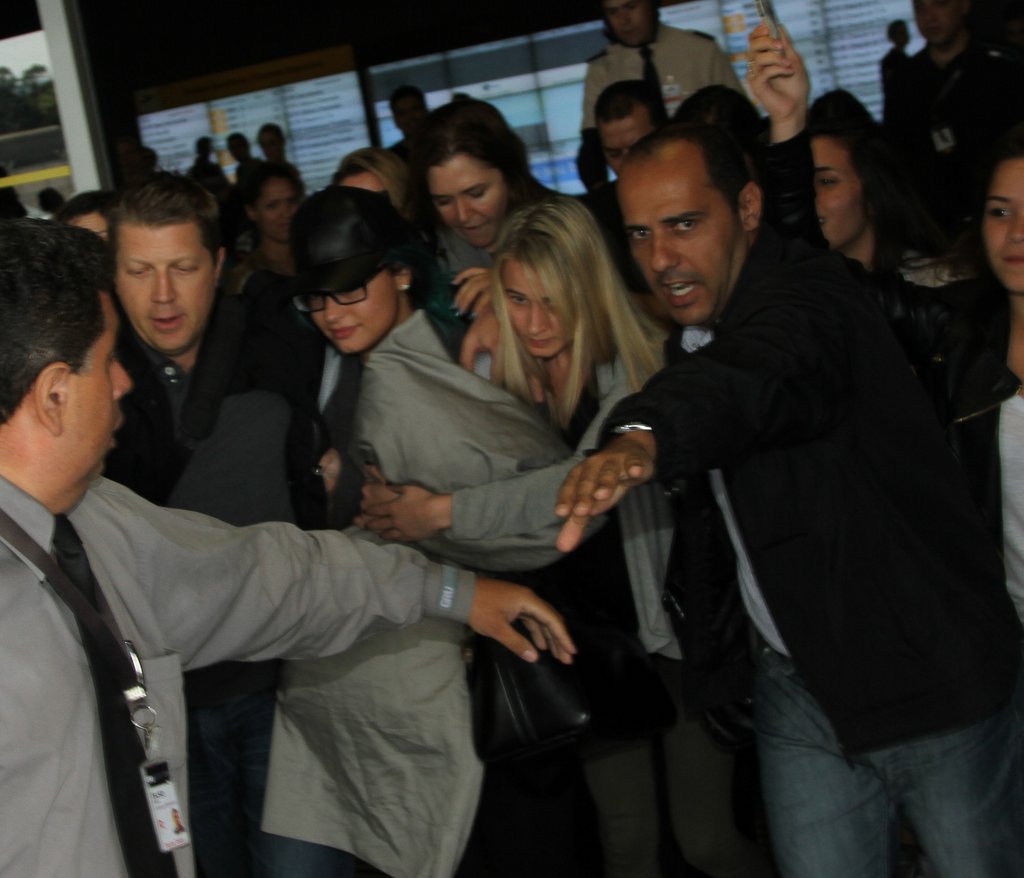 Demi Lovato desembarcou em Guarulhos, São Paulo, neste sábado, 12. Seguranças cercaram a cantora, que foi recebida por dezenas de fãs