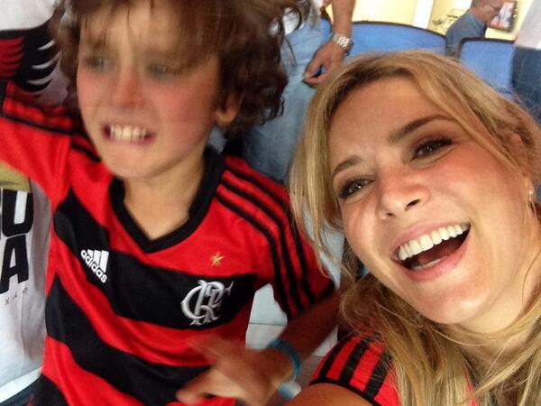 Christine Fernandes com o filho em estádio torcendo pelo Flamengo.