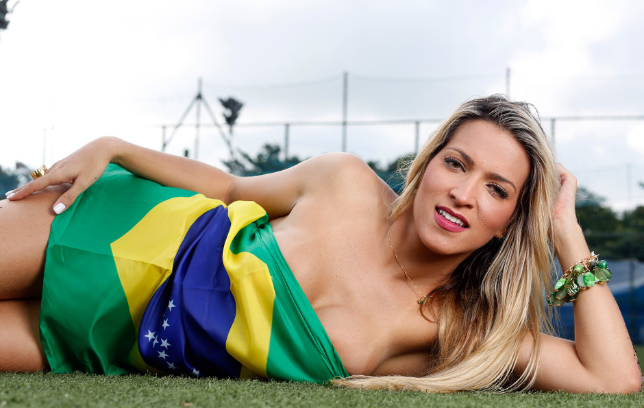 Dani Vieira foi posa enrolada na bandeira do Brasil em ensaio realizado em um campo de futebol no Rio 