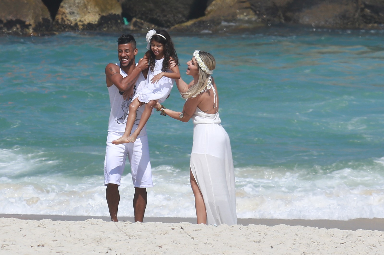 Vestidos de branco, Léo Moura, a mulher, Camila Silva, e a filhinha, Isabella, posaram para uma sessão de fotos na praia 