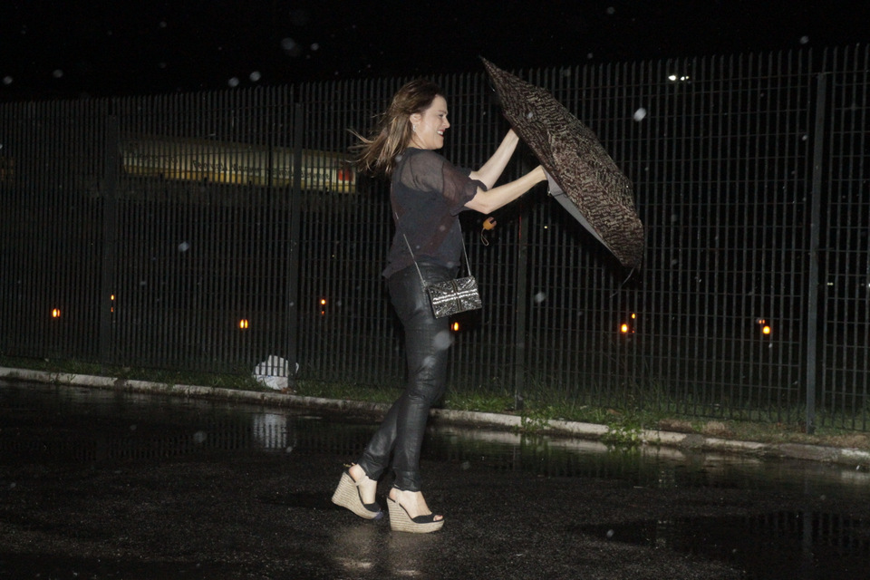 Vivianne Pasmanter tentou se proteger com um guarda-chuva mas...