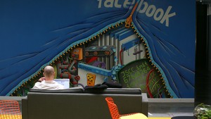 Funcionário trabalha em seu computador na nova sede do Facebook, que traz espaços abertos de trabalho (Foto: Robert Galbraith/Reuters)