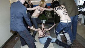 Três manifestantes do grupo ucraniano Femen, conhecido por seu protesto contra violações aos direitos humanos reunindo mulheres seminuas, é detida em seção eleitoral em Moscou, na Rússia, na manhã deste domingo (4) (Foto: Denis Sinyakov/Reuters)