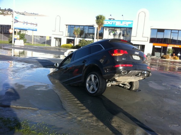 Carro afunda em buraco aberto no asfalto após o terremoto que atingiu a cidade de Christchurch, Nova Zelândia (Foto: Tim Kelleher/Reuters)