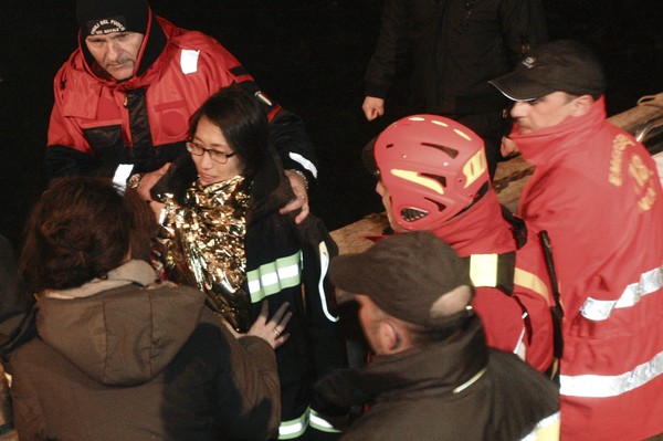 Mulher recebe ajuda após ser resgatada junto com homem do navio de cruzeiro acidentado. Segundo mídia local, os dois estavam em lua de mel (Foto: Reuters)